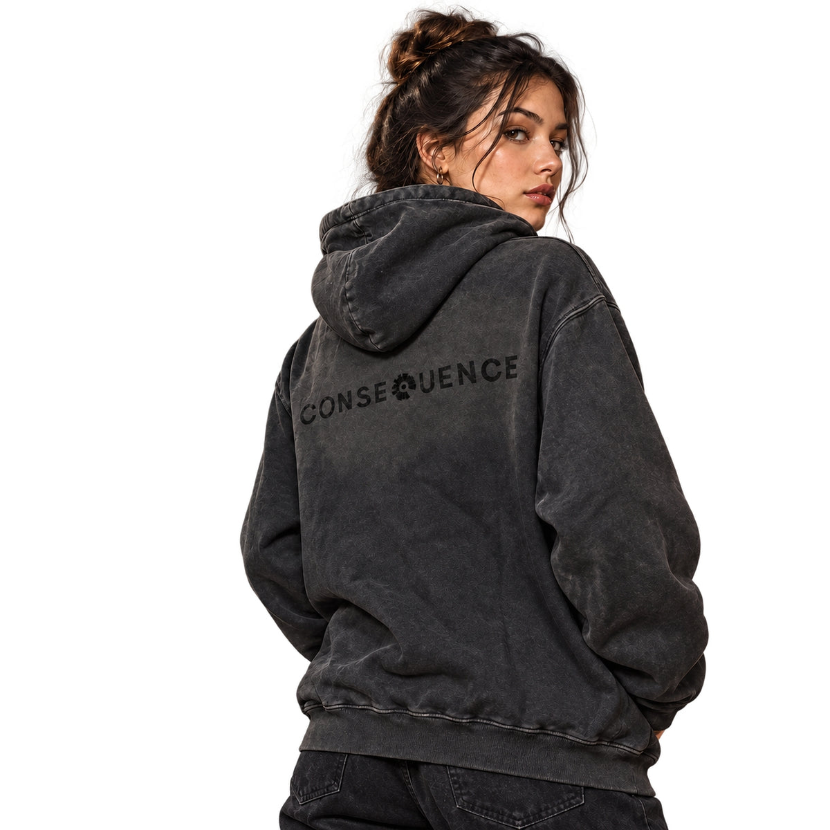 A woman wearing a washed black hooded sweatshirt with 'CONSEQUENCE' printed across the back, shown from a rear three-quarter view against a plain white background.